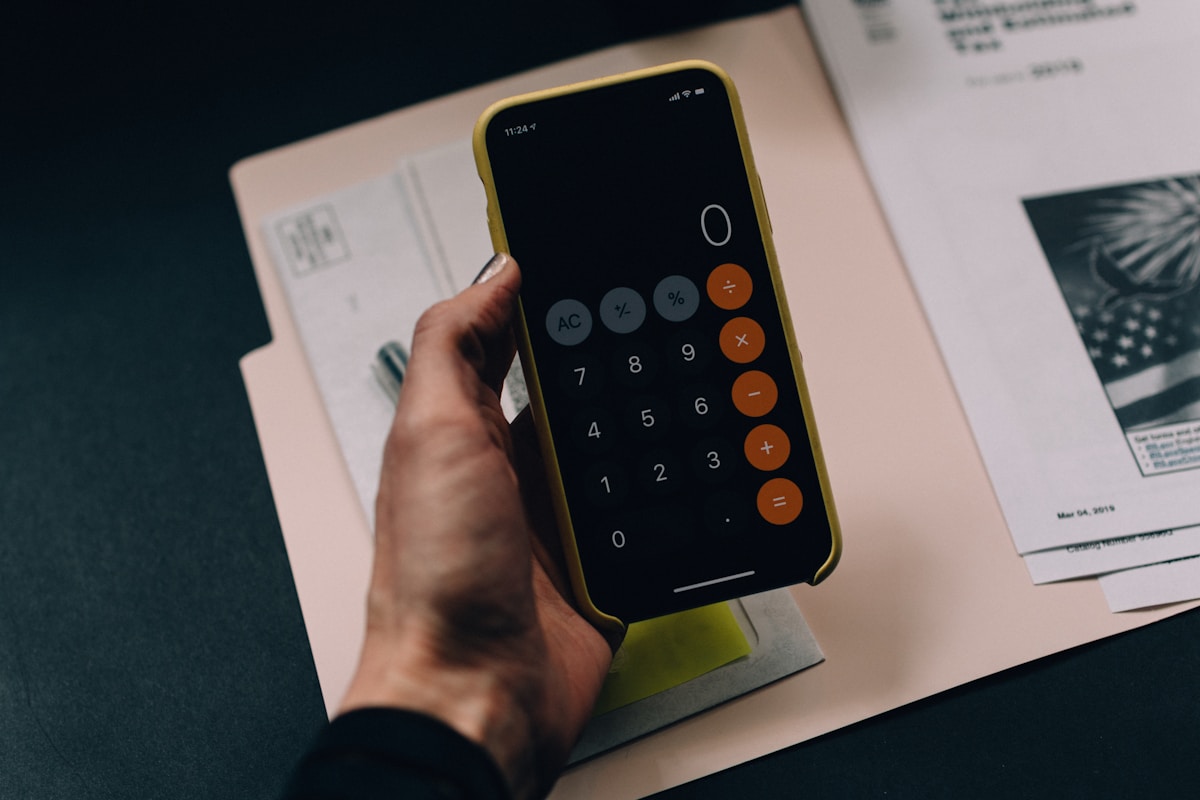 A desk showing a calculator, financial documents, and a structured pricing sheet.
